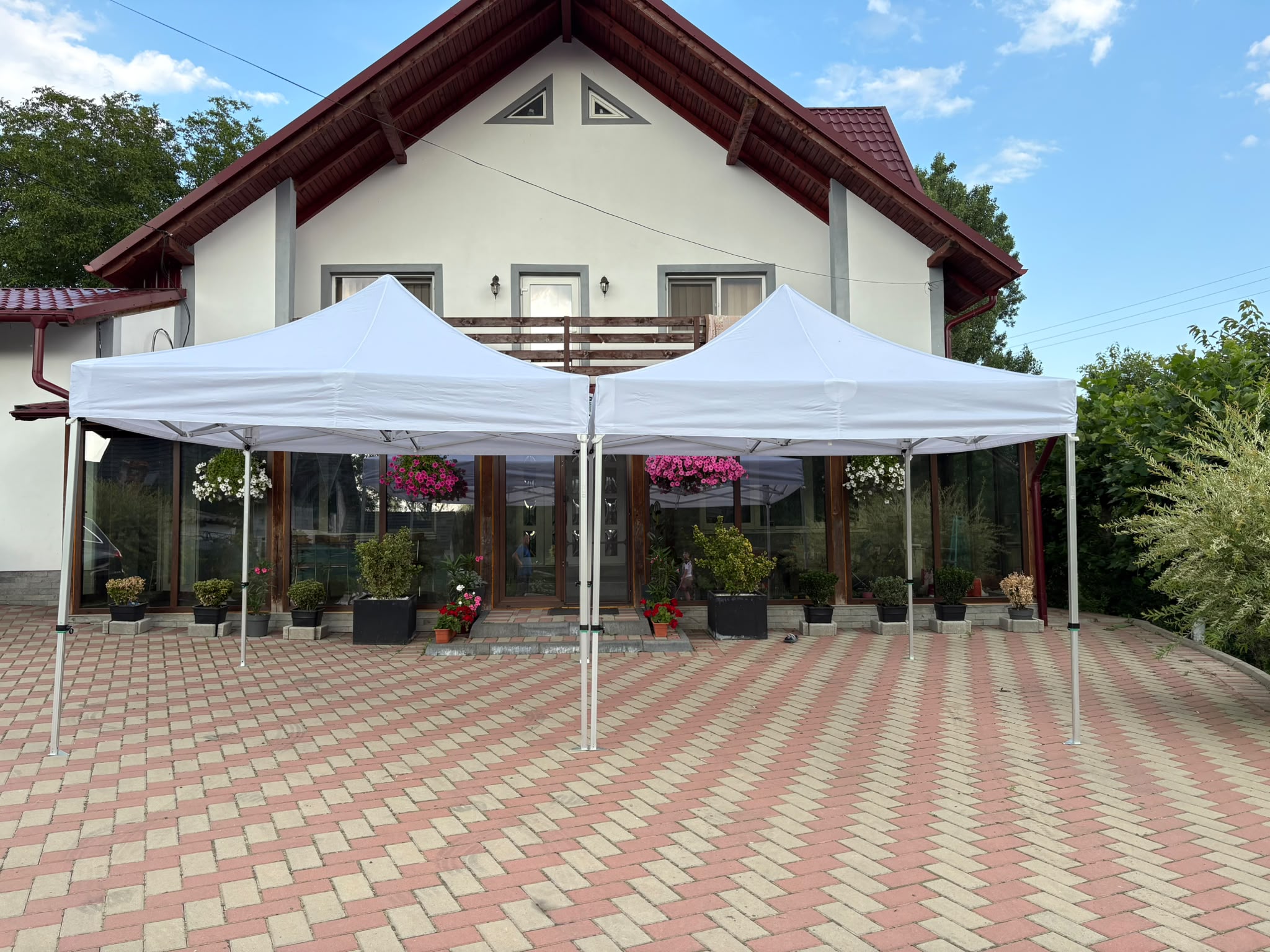 Două corturi albe montate pe o terasă pentru eveniment