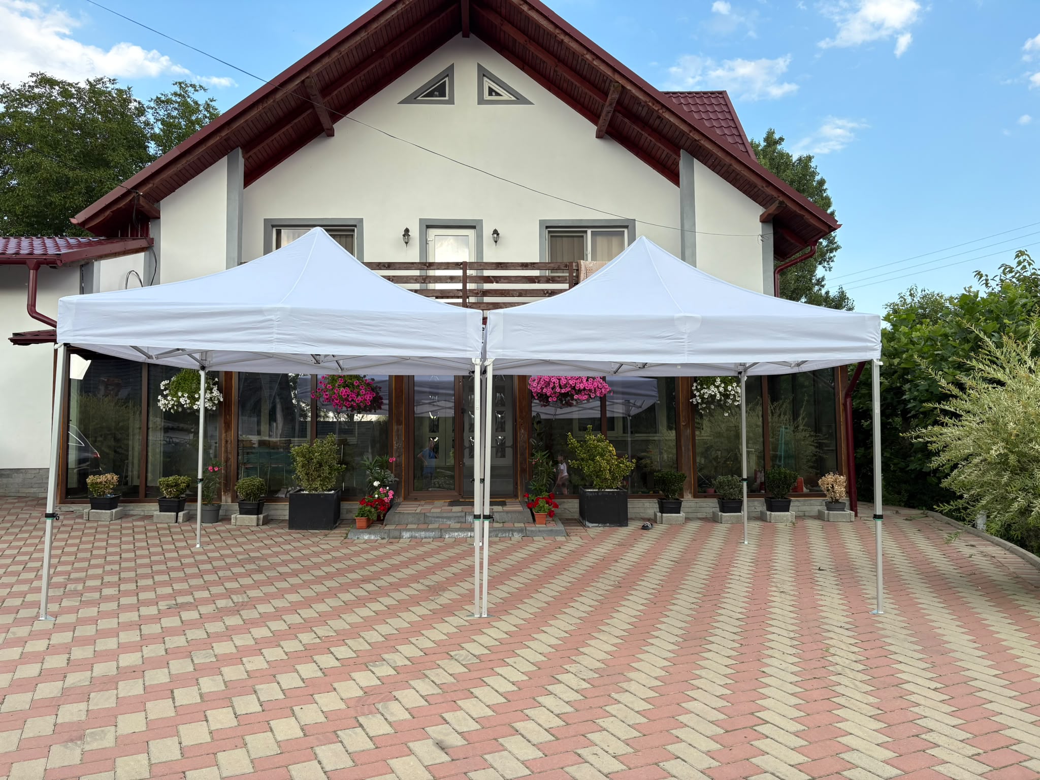 Două corturi albe unite pentru spațiu extins